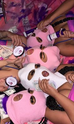 several girls in pink masks with money around them