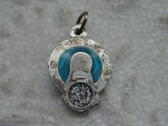 "Religious plique-a-jour silvered medal pendant charm medallion of Holy Virgin Mary and the cave of Lourdes with Saint Bernadette. Measures: 0,67 x 0,68 inches ( 1,71 x 1,74 cm ) Plique-à-jour (French for \"letting in daylight\") is a vitreous enamelling technique where the enamel is applied in cells, similar to cloisonné, but with no backing in the final product, so light can shine through the transparent or translucent enamel. It is in effect a miniature version of stained-glass and is conside Miraculous Medal For Commemoration, Silver Round Pendant For Memorial, Silver Miraculous Medal Pendant, Silver Pendant With Miraculous Medal, Saint Bernadette, The Cave, Virgin Mary, Pocket Watch, Stained Glass