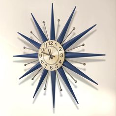 a clock that is on the wall with blue and white stripes around it's face