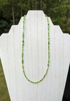 "This charming beaded necklace is reminiscent of a sunny forest, handmade with a variety of green and gold seed and bugle beads. It measures ~18 inches and was finished with a ~2 inch silver-toned adjustable necklace chain, lobster clasp closure, crimp beads, and jump rings.  This piece has the flexibility to act as a standalone item or as a layer in a necklace set you already own. All BullCityBeadworks necklaces are crafted with Beadalon 7-Strand 0.012\" (0.30 mm) Bright Bead Stringing Wire, which is made of stainless steel and is abrasion-resistant. I hope you enjoy my pieces as much as I loved making them! In order to maintain their quality and color, please handle with care and keep dry. If you would like this item a different color or design, feel free to send me a message. Custom ord Gift Green Beaded Necklaces With Faceted Beads, Green Beaded Necklace With Gold Beads For Festival, Green Necklaces With Spacer Beads For Festivals, Green Necklaces With Tiny Round Beads, Green Necklaces With Gold Beads For Jewelry Making, Green Necklace With Gold Beads As Gift, Green Necklace With Spacer Beads For Festivals, Green Tiny Beads Necklace For Festival, Green Necklace With Gold Beads For Gift