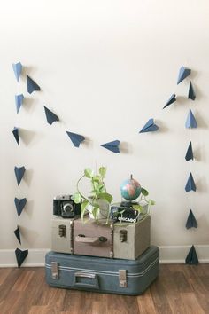 a suitcase sitting on top of a hard wood floor next to a wall with blue triangles