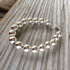 "Beautiful! Classy but simple everyday wear. All shiny round ball 10mm sterling silver bead bracelet. 10mm (LARGE) smooth shiny ball sterling silver beads. 🚩 IMPORTANT IMPORTANT 🚩 10mm are LARGE beads which affects the INSIDE circumference and takes up more room than smaller beads. Please allow a extra room when choosing length. MEASURE WRIST: wrap string around wrist (not tight) and measure end to end. Add about 3/4\" - 1\", depending on your \"comfort\" fit length - loose fit or snug fit. Le Adjustable Sterling Silver Ball Chain Bracelet, Sterling Silver Bracelet With Round Spacer Beads For Everyday, Sterling Silver Bracelets With Round Beads, Everyday Silver Bracelets With Polished Beads, Everyday Silver Bracelet With Polished Beads, Everyday Sterling Silver Bracelet With Silver Beads, Classic Sterling Silver Bracelet With Silver Beads, Silver Ball Chain Bracelet For Everyday, Silver Beaded Ball Chain Bracelet