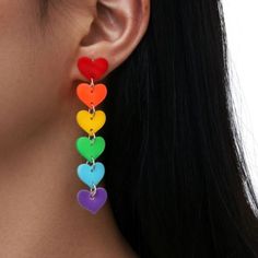 a woman wearing colorful heart shaped earrings