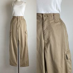 90s / early 2000 khaki pleated cargo pants. men's pants but cute on anyone.  in some of the photos on my screen, it looks like there is discoloration. there is no discoloration.  (listing is for pants only) label: old navy label size: 32 X 34 100% cotton waist: 33" inseam: 34" outseam: 47" front rise: 13" back rise: 17" condition: there are two pale orange marks on the lower front portion of one of the legs which are not very noticeable. and another small one on the upper back of one of the legs as well as one on the front near the bottom cuff (see last photos). otherwise, excellent. 90s Cargo Style Wide Leg Parachute Pants, 90s Wide Leg Parachute Pants With Cargo Pockets, Vintage Baggy Cargo Pants With Cargo Pockets, Vintage Cargo Style Bottoms For Spring, Vintage Cargo Style Spring Bottoms, 90s Style Wide Leg Pants With Belt Loops, 90s Wide Leg Pants With Belt Loops, Vintage Spring Cargo Style Bottoms, Vintage Summer Cargo Pants With Cargo Pockets