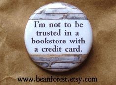 a button that says i'm not to be trusted in a bookstore with a credit card