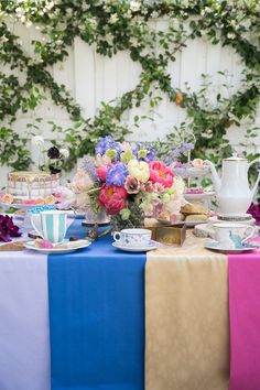 a table topped with plates and cups filled with flowers