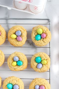 several cookies with eggs in the middle on a cooling rack next to an egg container