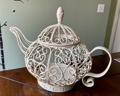 a white teapot sitting on top of a wooden table