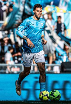 a soccer player is running with the ball in front of him and people watching from the stands