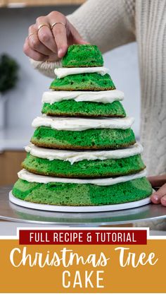 a christmas tree cake with green frosting and white icing is being cut into pieces