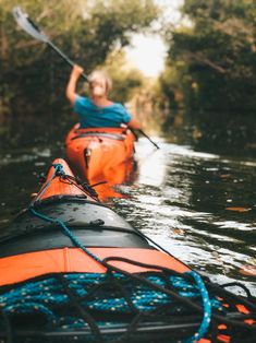 two people in kayaks paddling down a river