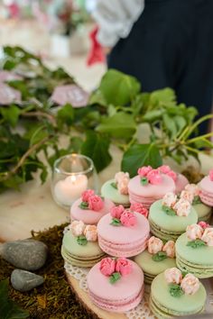 a table topped with lots of pink and green macaroons