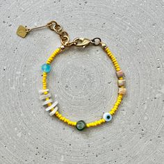 Colorful narrow bead bracelet with agate cubes, moonstone and jade nuggets, as well as yellow and turquoise glass beads and an Evil Eye charm. Perfect for your beach outfit! Matching earrings are also available for this bracelet: https://www.etsy.com/listing/1475446457 LENGTH The total length is approx. 20cm/7.8" and fits best on wrists between 16-18cm/6.3" to 7" thanks to the extension chain. If you need a different length, simply select the "custom length" option in the menu and specify your w Yellow Heishi Bead Bracelets, Yellow Heishi Beaded Bracelets, Bohemian Yellow Letter Beads, Yellow Bohemian Letter Beads, Bracelets With Gemstone And Heishi Beads, Yellow Beaded Bracelets With Colorful Beads For Beach, Colorful Beaded Bracelets For The Beach, Yellow Beaded Bracelets For Beach With Colorful Beads, Adjustable Yellow Beaded Bracelets With Spacer Beads