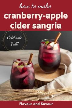 two glasses filled with cranberry - apple cider sangria on top of a wooden