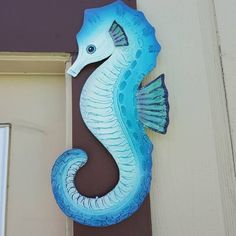 a blue seahorse is mounted to the side of a building