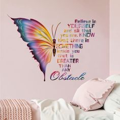 a bedroom with pink walls and a colorful butterfly on the wall