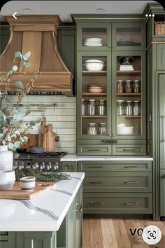 a kitchen with green cabinets and white counter tops