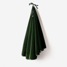 four green napkins hanging on a white wall