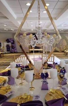 a table set up with purple and gold place settings for a wedding or special event