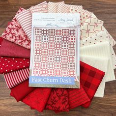 a pile of red and white fabric sitting on top of a wooden table next to each other