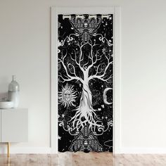 an open door with a black and white painting on it's side, showing the tree of life