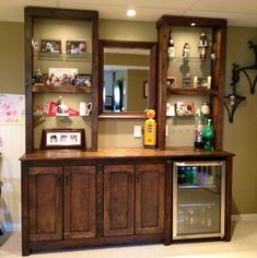 a wooden cabinet with glass doors and shelves on the top, in a living room