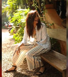 a woman sitting on a wooden bench smiling