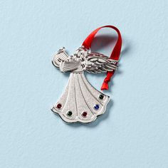 a silver ornament with a red ribbon around it and an angel on top