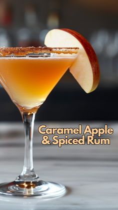 caramel apple and spiced rum cocktail in a martini glass with an apple slice on the rim