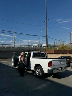 a white pickup truck parked next to a black fire hydrant in a parking lot