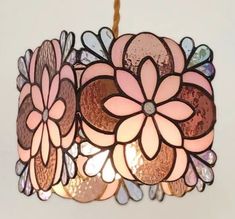 a pink and brown flower lamp hanging from a ceiling