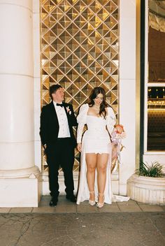 a man and woman standing in front of a building