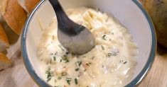 a spoon in a bowl filled with cheese and bread