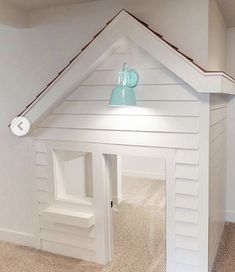 a dog house made out of white wood with a blue bell on the top and bottom