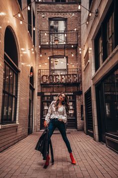 a woman standing in an alleyway with her legs crossed