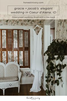 a wedding dress hanging in front of a window