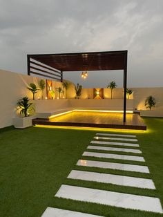 an outdoor area with grass and steps lit up by lights on either side of the walkway