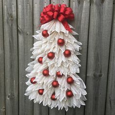 a christmas tree made out of paper with red balls and bows on it's head