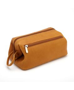 a tan leather toiletry bag with zippers on the front and side, sitting against a white background