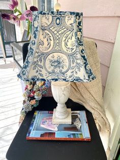 a lamp sitting on top of a table next to a book