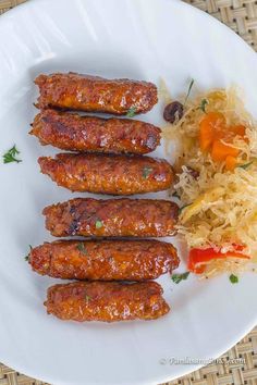 several sausages are on a plate with sauerkraut