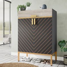 a black and gold cabinet in the corner of a room next to a potted plant