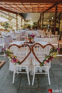 two heart - shaped chairs with flowers on them are set up for a wedding reception