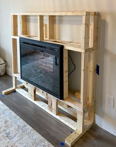 an entertainment center made out of pallet wood with a television on the top shelf