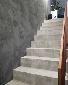 a set of white stairs leading up to a gray wall