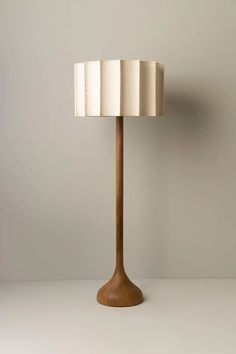 a wooden lamp with a white shade on it