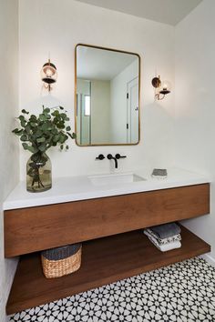 a bathroom with a sink, mirror and plant in the corner on the counter top