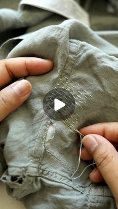 someone is stitching something on to an old piece of cloth