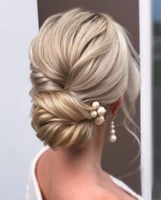 a woman with blonde hair and pearls in her hair