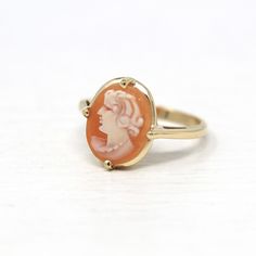 "Lovely vintage circa 1940s era 10k yellow gold cameo ring! This beautiful statement ring features a genuine carved shell cameo, that depicts a beautiful woman's silhouette. The carved shell cameo is securely prong set in the center of the polished, unadorned band. A stunning piece of fine 1940s era cameo jewelry! *Sale - price reduced from $450 USD to $440 USD.  ERA - Circa 1940s - Retro  METAL / MATERIAL - 10k yellow gold, genuine carved shell cameo. MARKINGS / HISTORY - Inside of shank is marked \"10k\" with a shield shape. CONDITION - Good vintage condition. Ring has been refurbished, polished, and cleaned by our jeweler. Prongs have all been re-tipped by our jeweler. Very little age remains to metal. Genuine shell is secure and is in nice shape. An amazing vintage cameo ring! SIZE / M Profile Silhouette, Cameo Jewelry, Jewelry Sale, Logo Gifts, Cameo Ring, Vintage Cameo, Carved Shell, Woman Silhouette, Timeless Jewelry